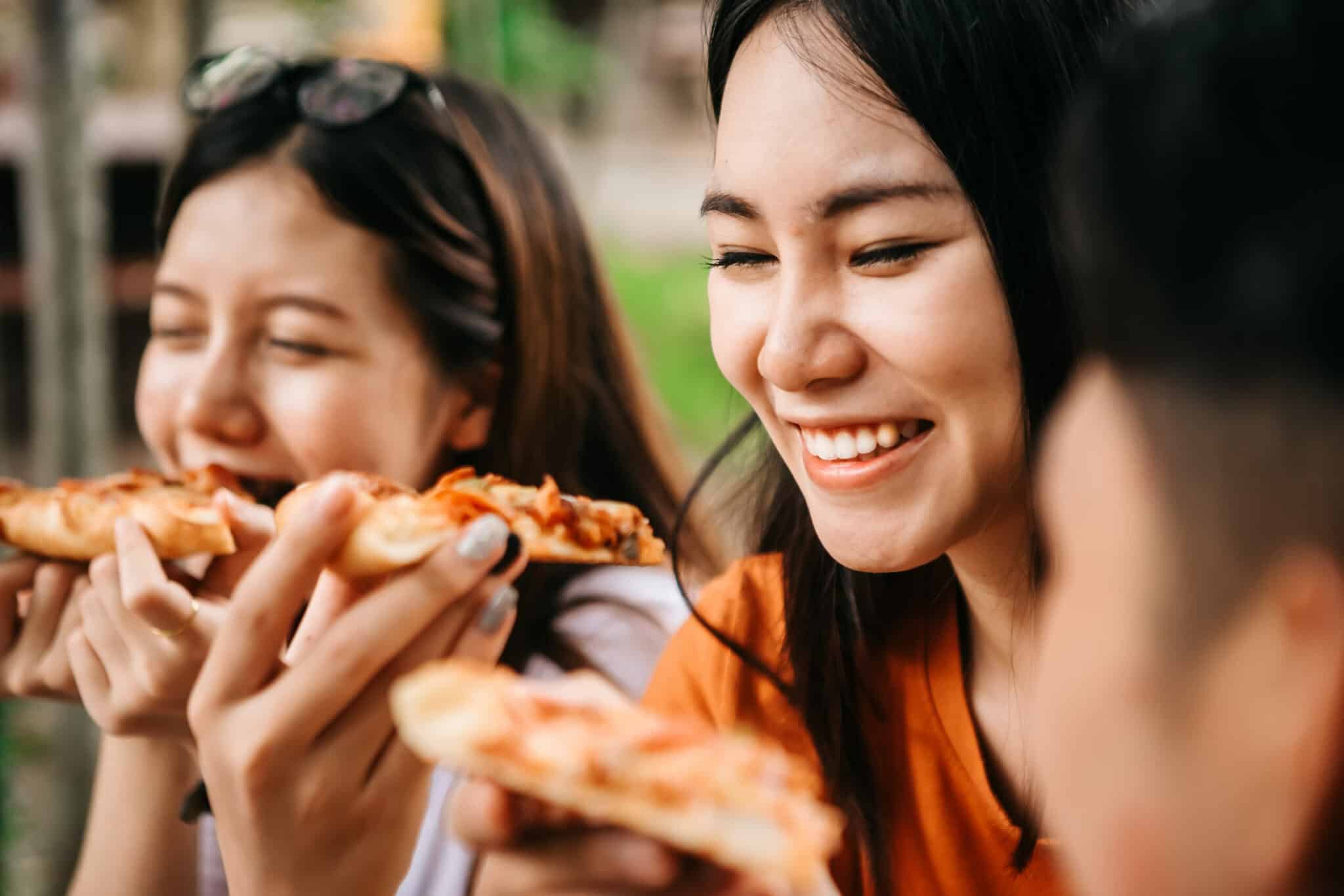 Asian,Students,Eating,Eating,The,Pizza,Together,In,Breaking,Time