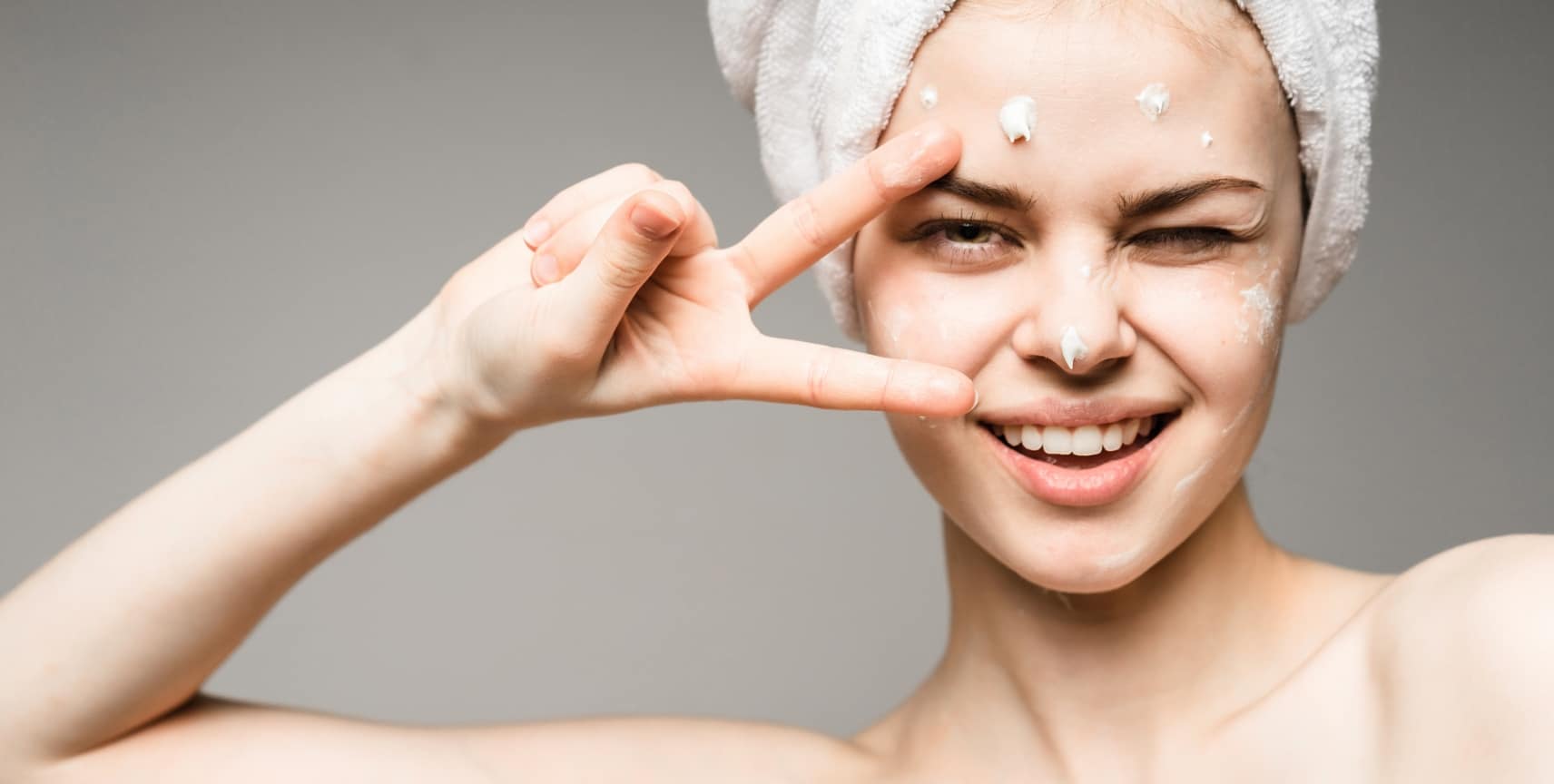 (Skin Health)stock-photo-close-up-of-beautiful-young-woman-applying-cream-with-bath-towel-on-head-covering-her-breasts-on-556550389